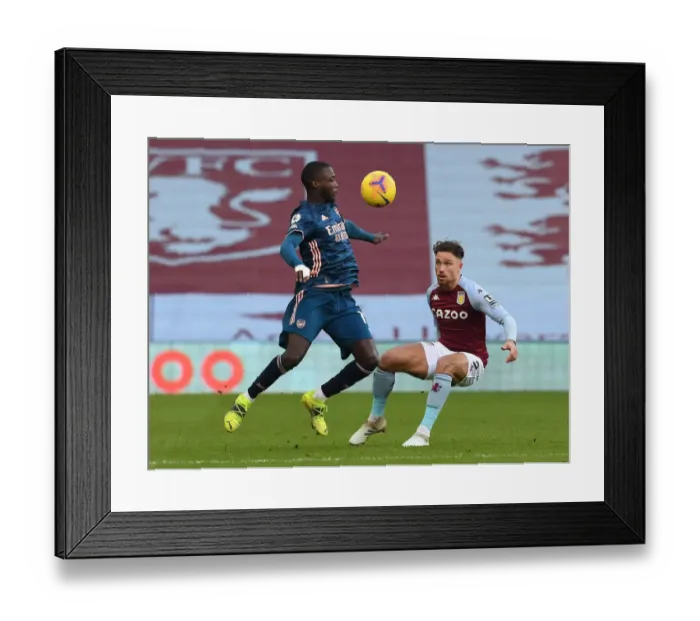 Framed Print : Arsenal's Nicolas Pepe Fends Off Aston Villa's Mathew Cash in Intense Premier League Clash
