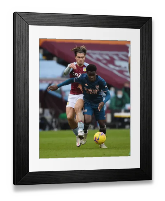Framed Print : Bukayo Saka vs Jack Grealish: A Riveting Rivalry in Empty Premier League Stands (Aston Villa vs Arsenal, 2021)