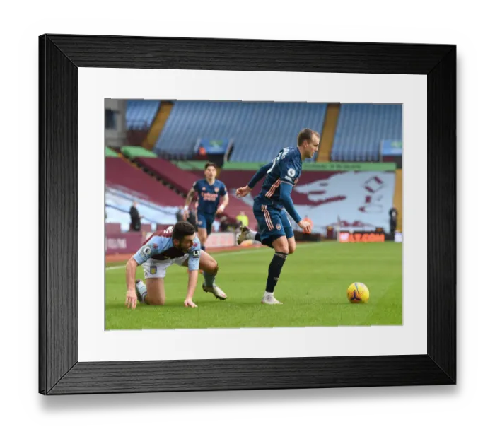 Framed Print : Arsenal's Rob Holding Outmaneuvers Aston Villa's John McGinn in Empty Villa Park Framed Print : Arsenal's Rob Holding Outmaneuvers Aston Villa's John McGinn in Empty Villa Park