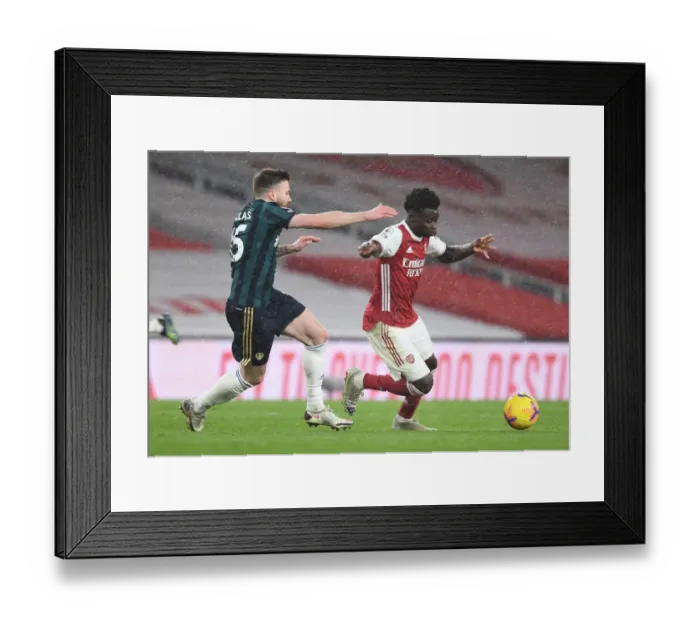Framed Print : Arsenal's Bukayo Saka Clashes with Leeds United's Stuart Dallas in Premier League Showdown Framed Print : Arsenal's Bukayo Saka Clashes with Leeds United's Stuart Dallas in Premier League Showdown