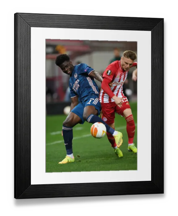Framed Print : Bukayo Saka Faces Off Against Olympiacos in Empty Europa League Arena Framed Print : Bukayo Saka Faces Off Against Olympiacos in Empty Europa League Arena