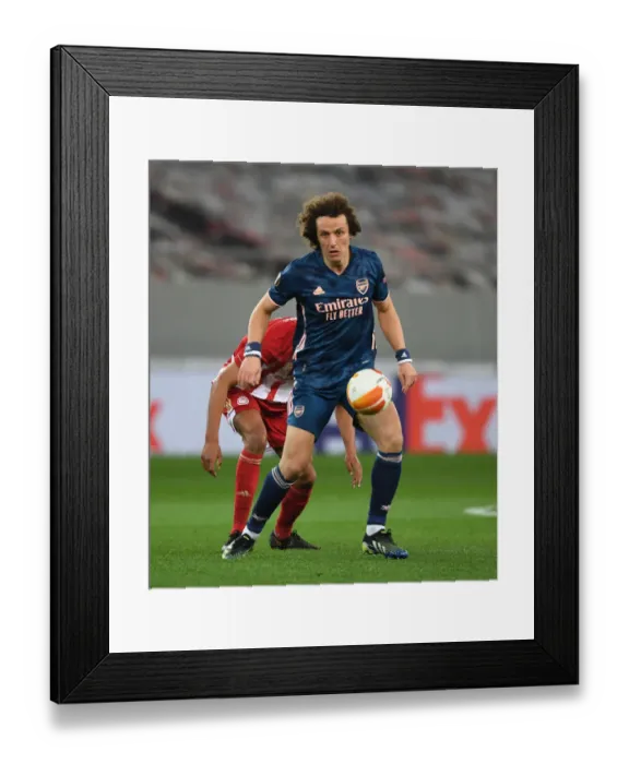 Framed Print : Arsenal's David Luiz Battles Through Olympiacos in Empty Europa League Stadium Framed Print : Arsenal's David Luiz Battles Through Olympiacos in Empty Europa League Stadium