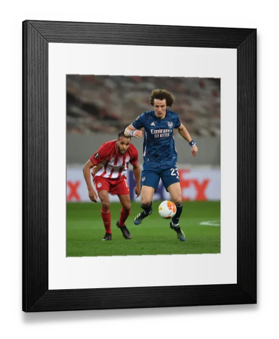Framed Print : Arsenal's David Luiz Battles Past Olympiacos in Empty Europa League Stadium Framed Print : Arsenal's David Luiz Battles Past Olympiacos in Empty Europa League Stadium