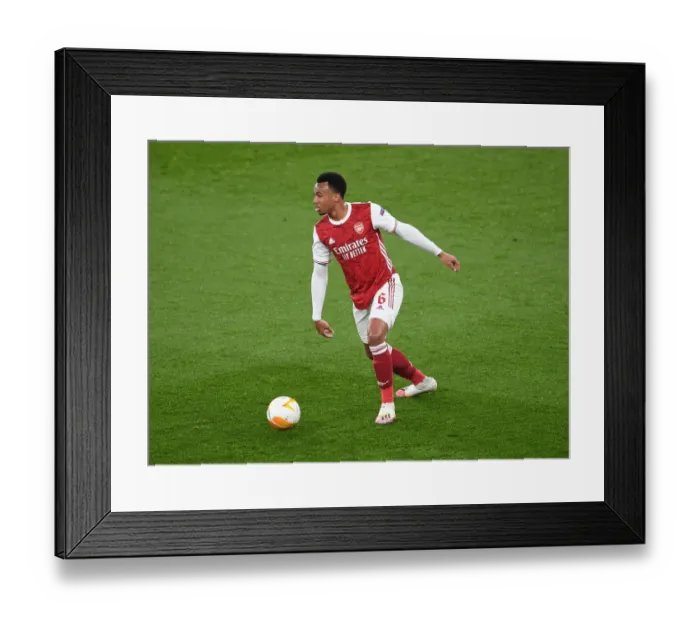 Framed Print : Gabriel Magalhaes: Arsenal's Unyielding Defender in Empty Emirates Stadium during Europa League Clash against Olympiacos Framed Print : Gabriel Magalhaes: Arsenal's Unyielding Defender in Empty Emirates Stadium during Europa League Clash against Olympiacos