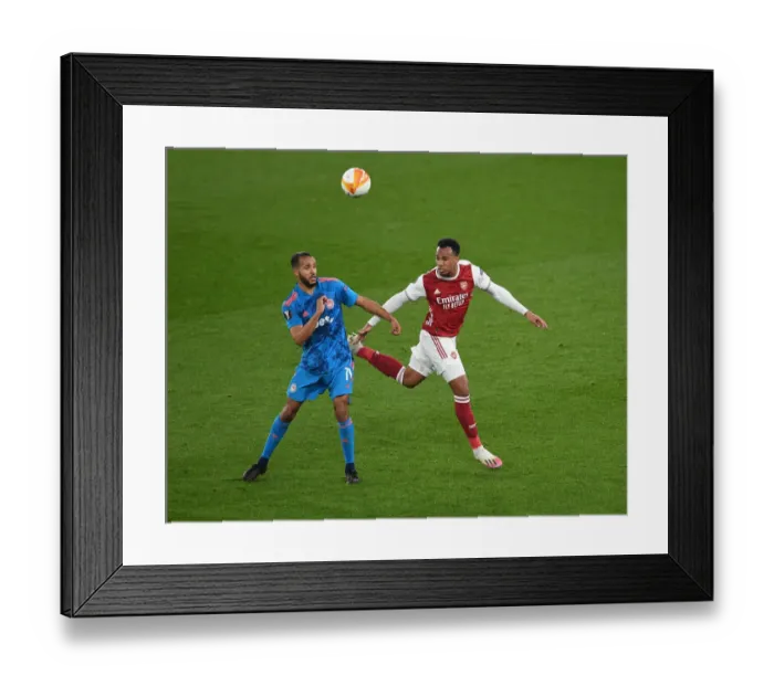 Framed Print : Arsenal vs Olympiacos: Gabriel Magalhaes Heads Away Under Pressure in Emirates Stadium - UEFA Europa League Round of 16 (Behind Closed Doors)