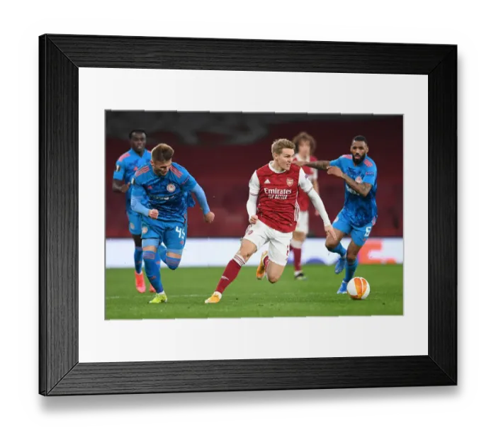 Framed Print : Martin Odegaard Alone: Arsenal's Emirates Stadium Showdown Against Olympiacos in Empty Europa League Arena