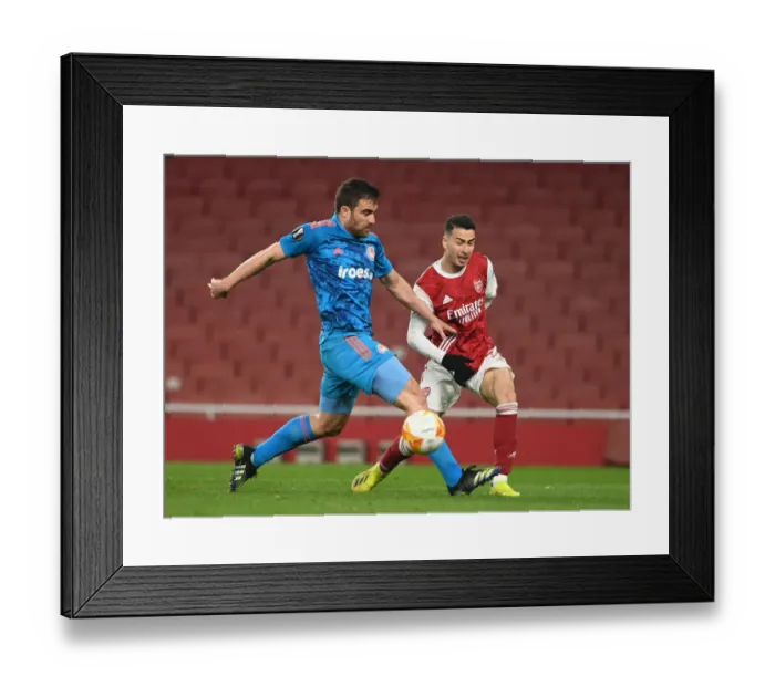 Framed Print : Arsenal vs. Olympiacos: Martinelli Crosses Amid Empty Emirates in Europa League Showdown