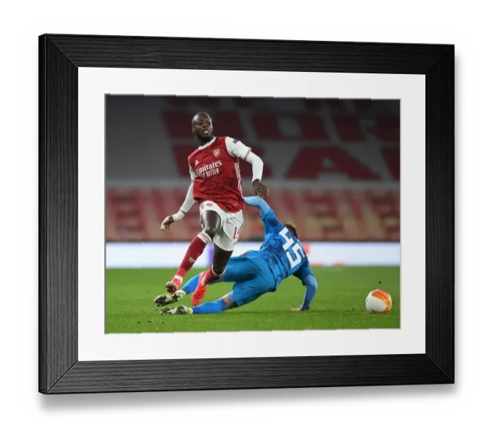 Framed Print : Arsenal's Nicolas Pepe Breaks Past Olympiacos Defender in Empty Emirates Stadium - Arsenal v Olympiacos, UEFA Europa League 2020-21