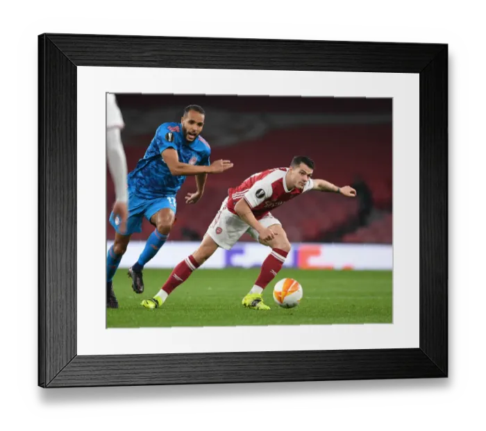 Framed Print : Arsenal's Granit Xhaka Battles Past Olympiacos in Empty Emirates Stadium - UEFA Europa League Round of 16