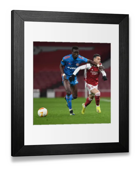 Framed Print : Arsenal's Martinelli Fouls Ba in Empty Europa League Clash: Arsenal vs. Olympiacos Framed Print : Arsenal's Martinelli Fouls Ba in Empty Europa League Clash: Arsenal vs. Olympiacos