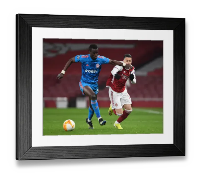 Framed Print : Arsenal vs. Olympiacos: Martinelli Fouls Ousseynou Ba in Empty Europa League Clash