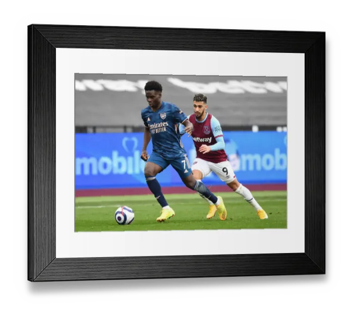 Framed Print : Bukayo Saka's Agile Moves: Arsenal's Empty-Stadium Triumph Over West Ham, Premier League 2020-21