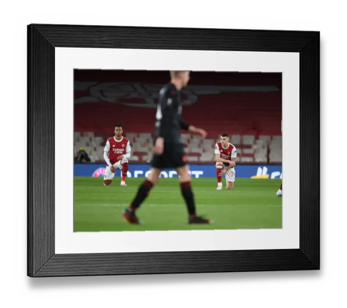 Framed Print : Arsenal's Gabriel and Xhaka Kneel Before Empty Emirates Stadium in Europa League Quarterfinal vs Slavia Praha