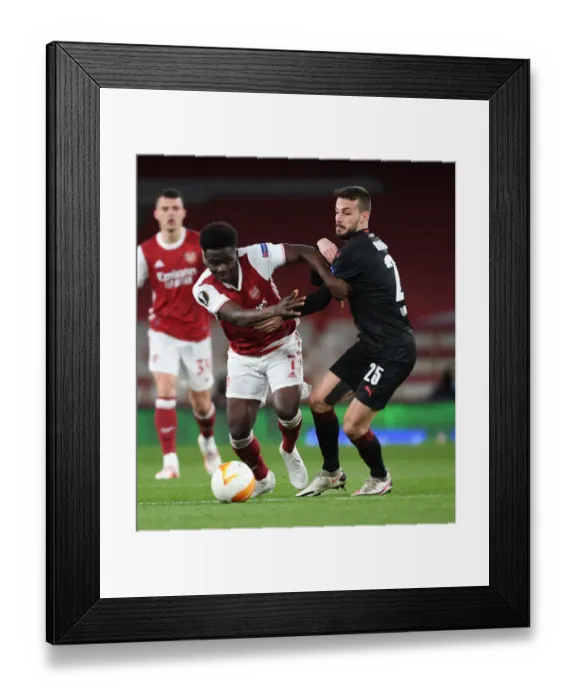 Framed Print : Bukayo Saka in Empty Emirates Stadium: Arsenal's Lone Warrior in Europa League Quarterfinal vs Slavia Praha, London, 2021