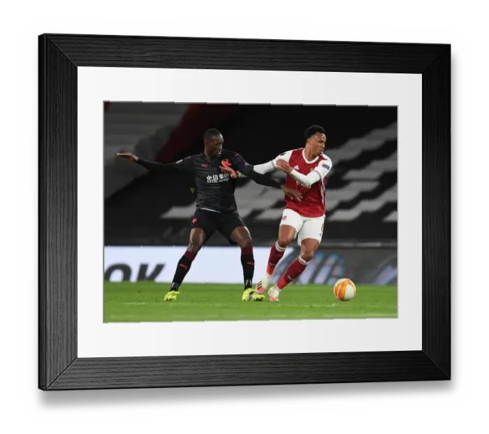 Framed Print : Arsenal's Gabriel Breaks Past Slavia Praha's Sima in Empty Europa League Quarterfinal Framed Print : Arsenal's Gabriel Breaks Past Slavia Praha's Sima in Empty Europa League Quarterfinal