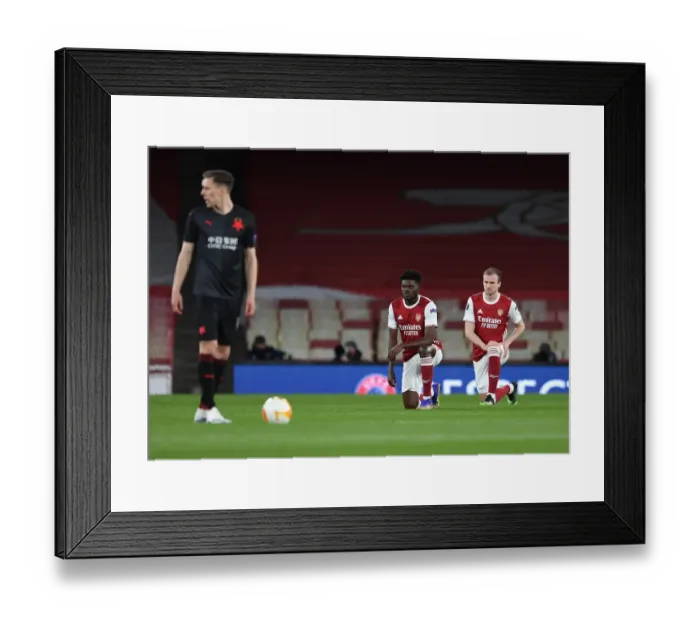 Framed Print : Arsenal's Thomas Partey and Rob Holding Kneel during Empty Emirates Stadium for Europa League Quarterfinal vs Slavia Praha