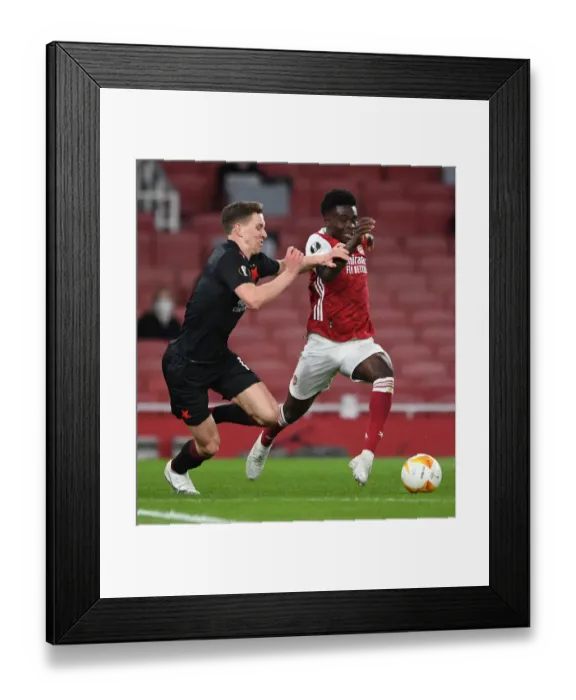 Framed Print : Arsenal's Bukayo Saka Faces Off Against Slavia Praha's Lukas Provod in UEFA Europa League Quarterfinal at Empty Emirates Stadium Framed Print : Arsenal's Bukayo Saka Faces Off Against Slavia Praha's Lukas Provod in UEFA Europa League Quarterfinal at Empty Emirates Stadium