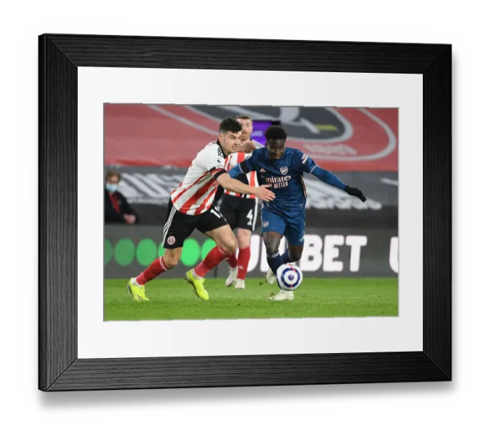 Framed Print : Arsenal's Bukayo Saka Outmaneuvers Sheffield United's John Egan in Empty Bramall Lane