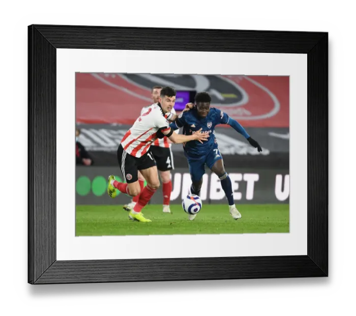 Framed Print : Arsenal's Bukayo Saka Outsmarts Sheffield United's John Egan in Empty Bramall Lane Framed Print : Arsenal's Bukayo Saka Outsmarts Sheffield United's John Egan in Empty Bramall Lane
