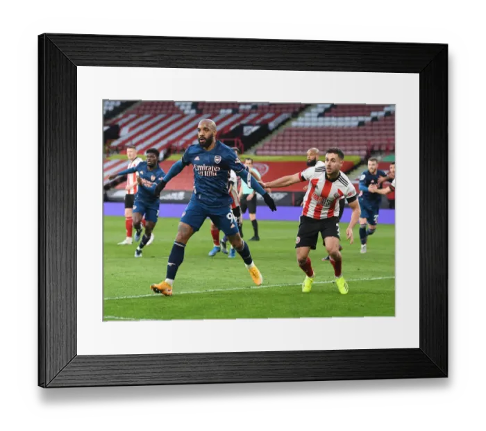 Framed Print : Arsenal's Lacazette Faces Off Against Sheffield United's Baldock in Empty Bramall Lane Framed Print : Arsenal's Lacazette Faces Off Against Sheffield United's Baldock in Empty Bramall Lane