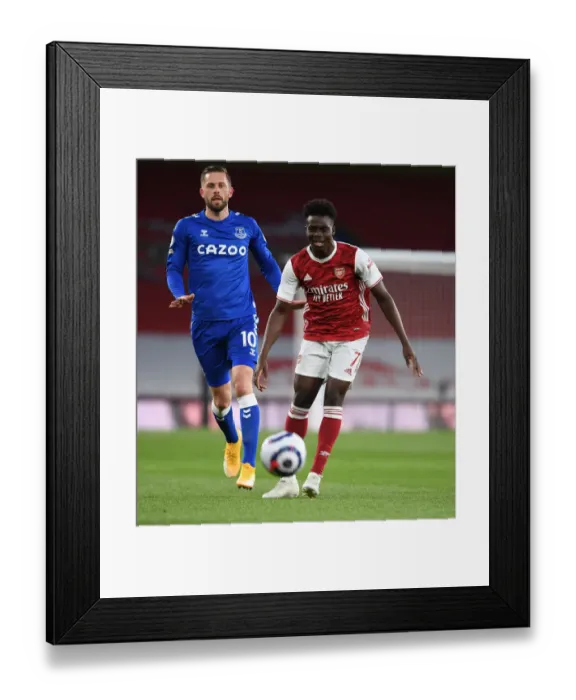 Framed Print : Saka Outsmarts Sigurdsson: Arsenal's Star Winger Dazzles in Empty Emirates Stadium Framed Print : Saka Outsmarts Sigurdsson: Arsenal's Star Winger Dazzles in Empty Emirates Stadium