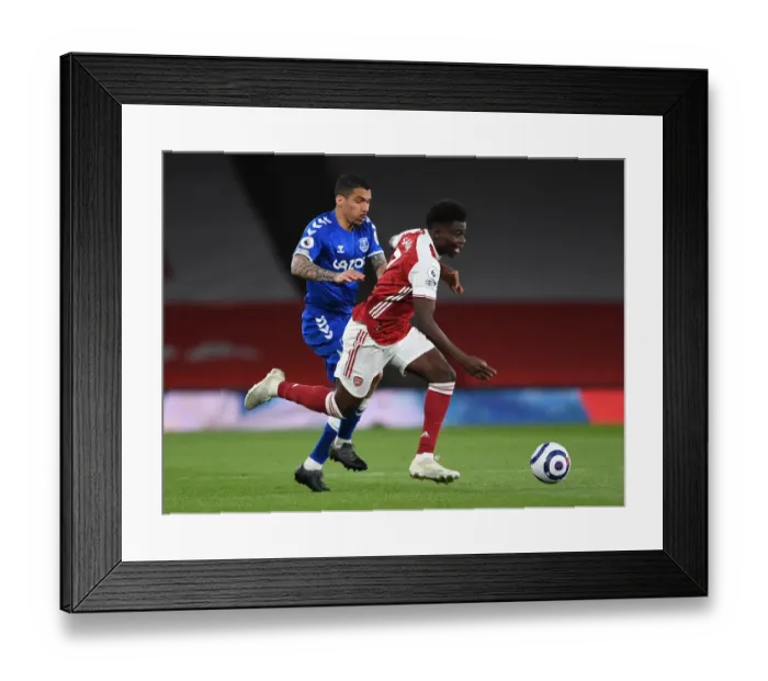 Framed Print : Arsenal's Bukayo Saka Clashes with Everton's Allan in Premier League Showdown