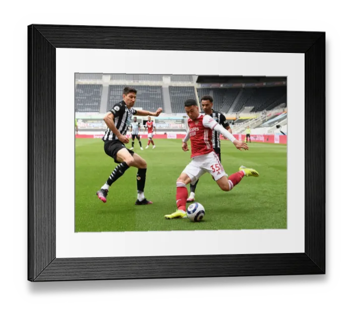Framed Print : Arsenal's Martinelli Faces Off Against Newcastle's Fernandez in Empty St. James Park