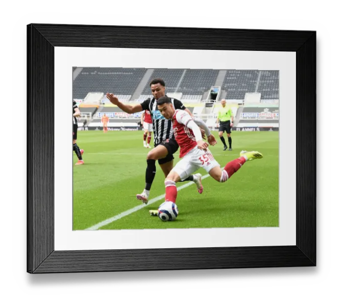 Framed Print : Gabriel Martinelli vs. Jacob Murphy: A Battle at Empty St. James Park - Newcastle United vs. Arsenal, Premier League 2021