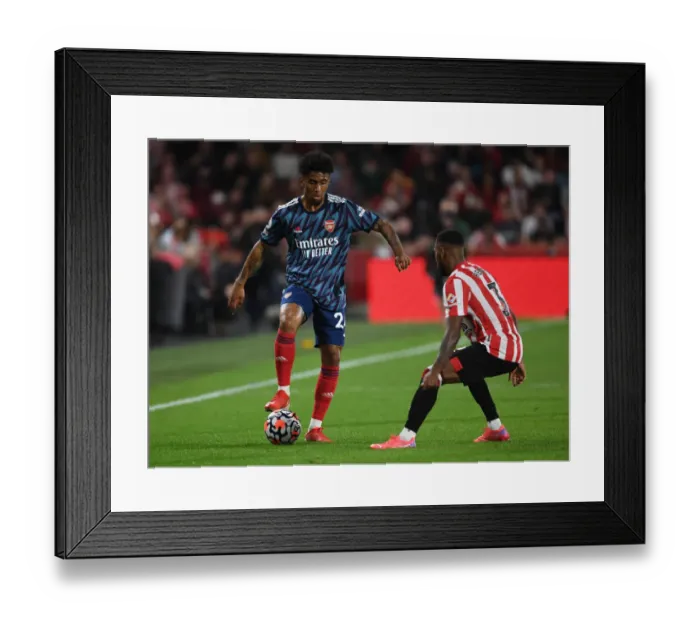 Framed Print : Reiss Nelson vs Rico Henry: Battle at Brentford Community Stadium - Arsenal vs Brentford, Premier League 2021-22