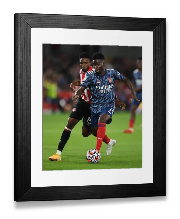 Framed Print : Saka vs. Onyeka: A Premier League Battle at Brentford Community Stadium