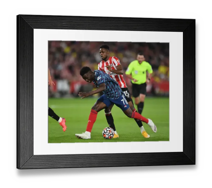 Framed Print : Bukayo Saka Clashes with Frank Onyeka: Intense Moment from Brentford vs. Arsenal, 2021-22 Premier League
