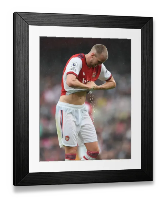 Framed Print : Arsenal vs. Chelsea: Rob Holding Wrings Out Drenched Shirt Amidst Premier League Downpour (2021-22) Framed Print : Arsenal vs. Chelsea: Rob Holding Wrings Out Drenched Shirt Amidst Premier League Downpour (2021-22)