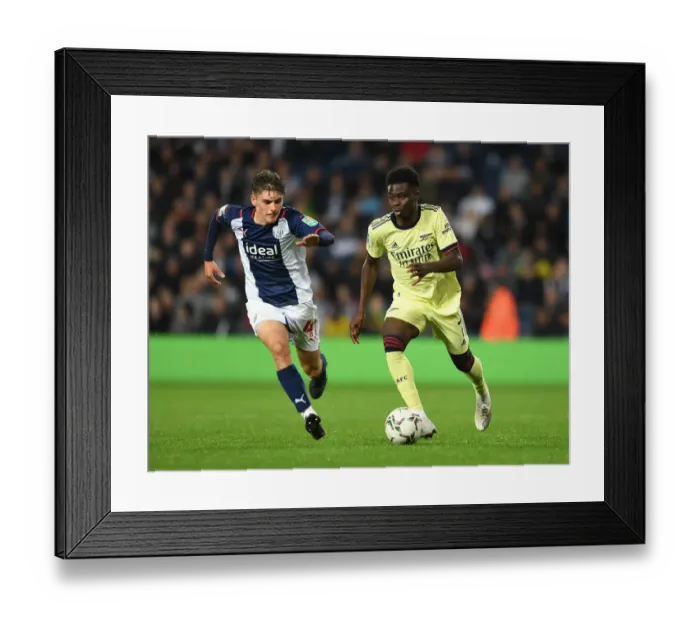 Framed Print : Arsenal's Bukayo Saka Clashes with Tom Fellows in Carabao Cup Battle at West Bromwich Albion