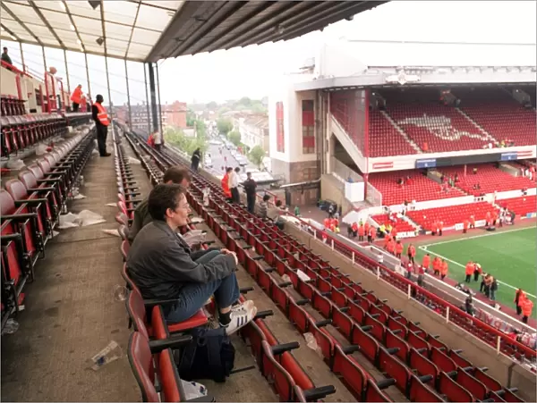 Fans sit in the North Bank as Arsenal Stadium empties after the match and Final Salute Events