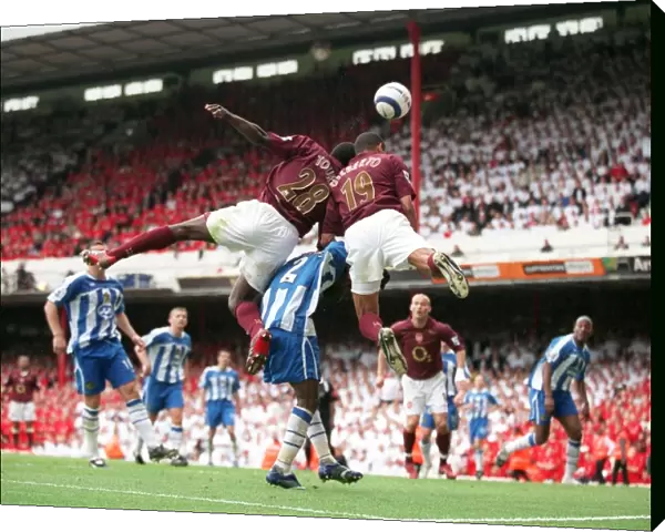 Gilberto and Kolo Toure (Arsenal) jump for the ball with Pascal Chimbonda (Wigan)