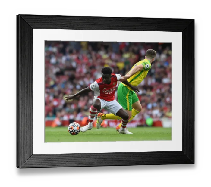 Framed Print : Arsenal's Bukayo Saka Fends Off Norwich's Grant Hanley During Premier League Clash Framed Print : Arsenal's Bukayo Saka Fends Off Norwich's Grant Hanley During Premier League Clash