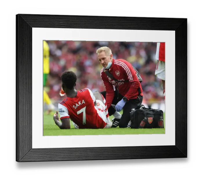 Framed Print : Arsenal's Bukayo Saka Receives Treatment from Physio during Arsenal v Norwich City Match, 2021-22 Season