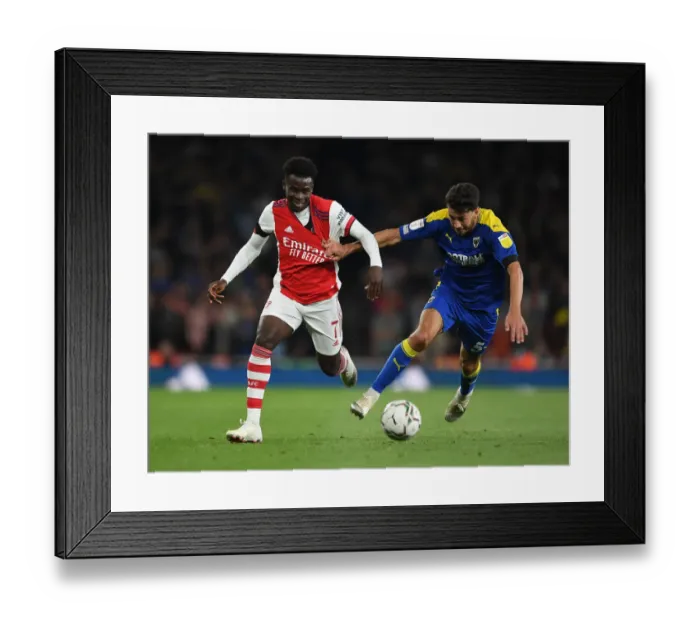 Framed Print : Arsenal's Bukayo Saka Faces Off Against Wimbledon's Will Nightingale in Carabao Cup Clash