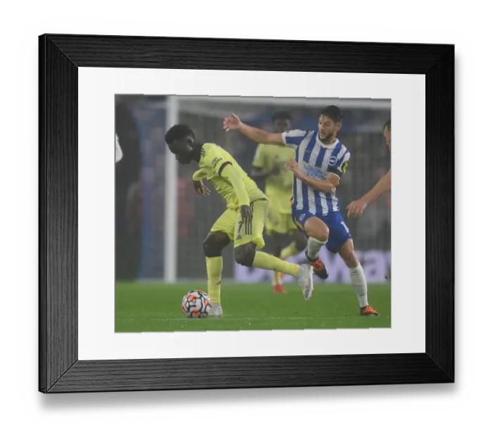 Framed Print : Brighton vs. Arsenal: Bukayo Saka Faces Off Against Adam Lallana