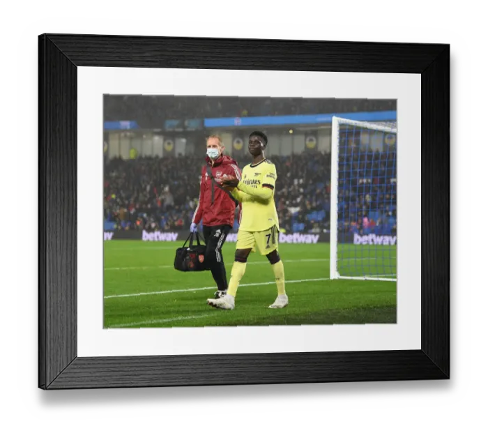 Framed Print : Arsenal's Bukayo Saka Receives Treatment from Physio during Brighton Match