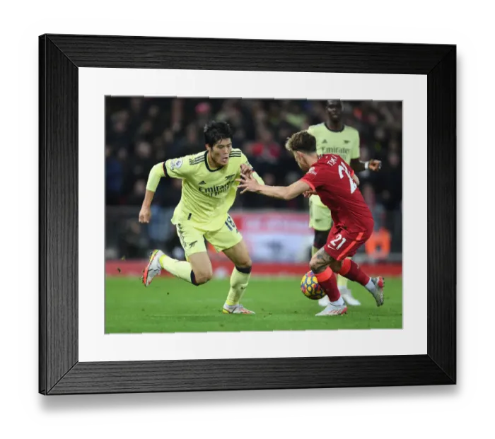 Framed Print : Clash at Anfield: Tomiyasu vs. Tsimikas in Premier League Showdown