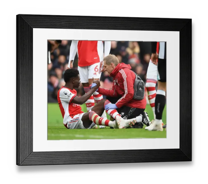 Framed Print : Arsenal's Bukayo Saka Receives Treatment from Physio Jordan Reece vs Newcastle United (2021-22)