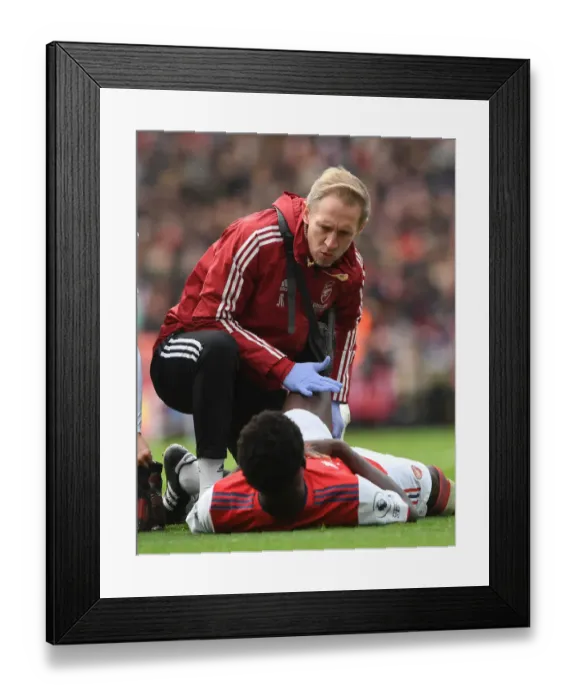 Framed Print : Arsenal: Bukayo Saka Receives Attention from Team Physio Amid Injury Concerns (Arsenal v Newcastle United, 2021-22)