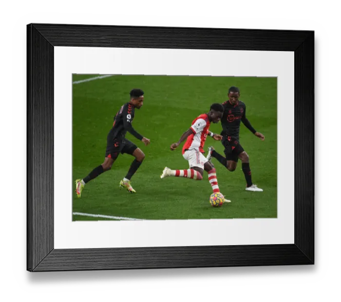 Framed Print : Arsenal's Bukayo Saka Tackles Southampton Duo in Premier League Clash