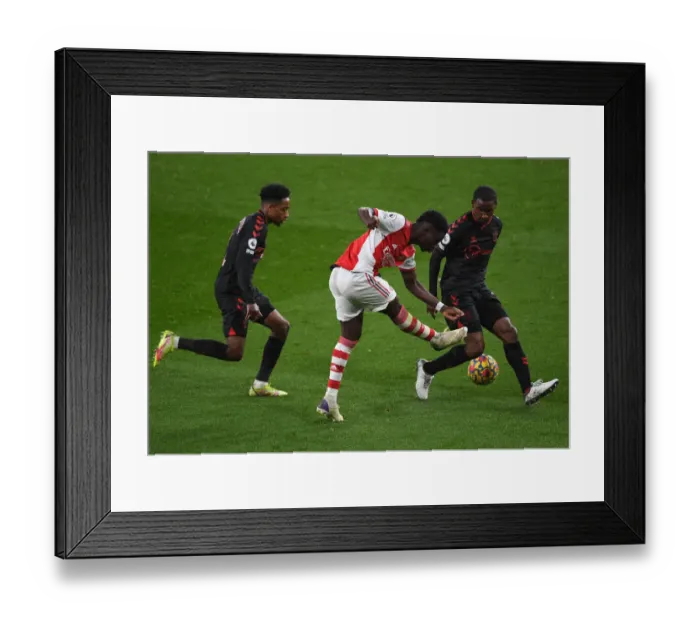 Framed Print : Arsenal's Bukayo Saka Takes on Southampton's Defense in Premier League Clash
