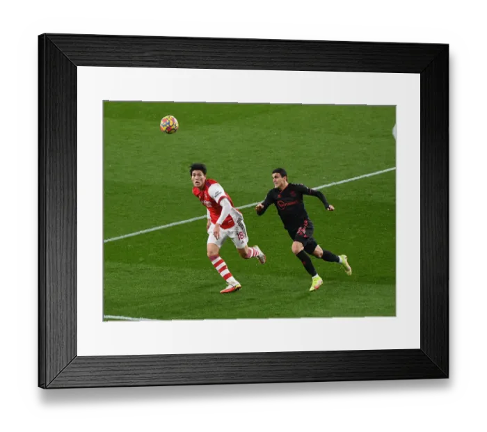 Framed Print : Arsenal vs Southampton: Tomiyasu Chases Elyounoussi in Premier League Clash at Emirates Stadium