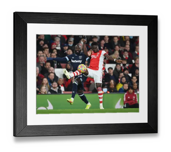 Framed Print : Arsenal's Bukayo Saka Outwits Arthur Masuaku: A Premier League Battle at Emirates Stadium