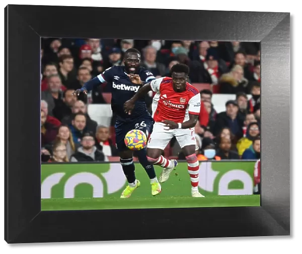 Arsenal's Bukayo Saka Outmaneuvers West Ham's Arthur Masuaku in Premier League Clash