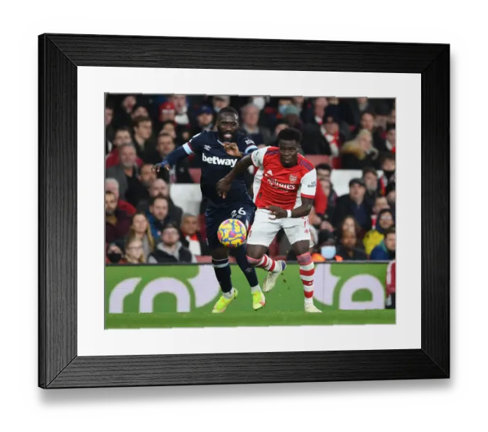Framed Print : Arsenal's Bukayo Saka Outmaneuvers West Ham's Arthur Masuaku in Premier League Clash