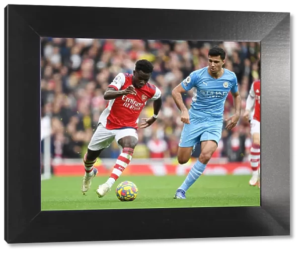 Arsenal's Bukayo Saka Takes on Rodri in Intense Arsenal v Manchester City Clash (Premier League 2021-22)